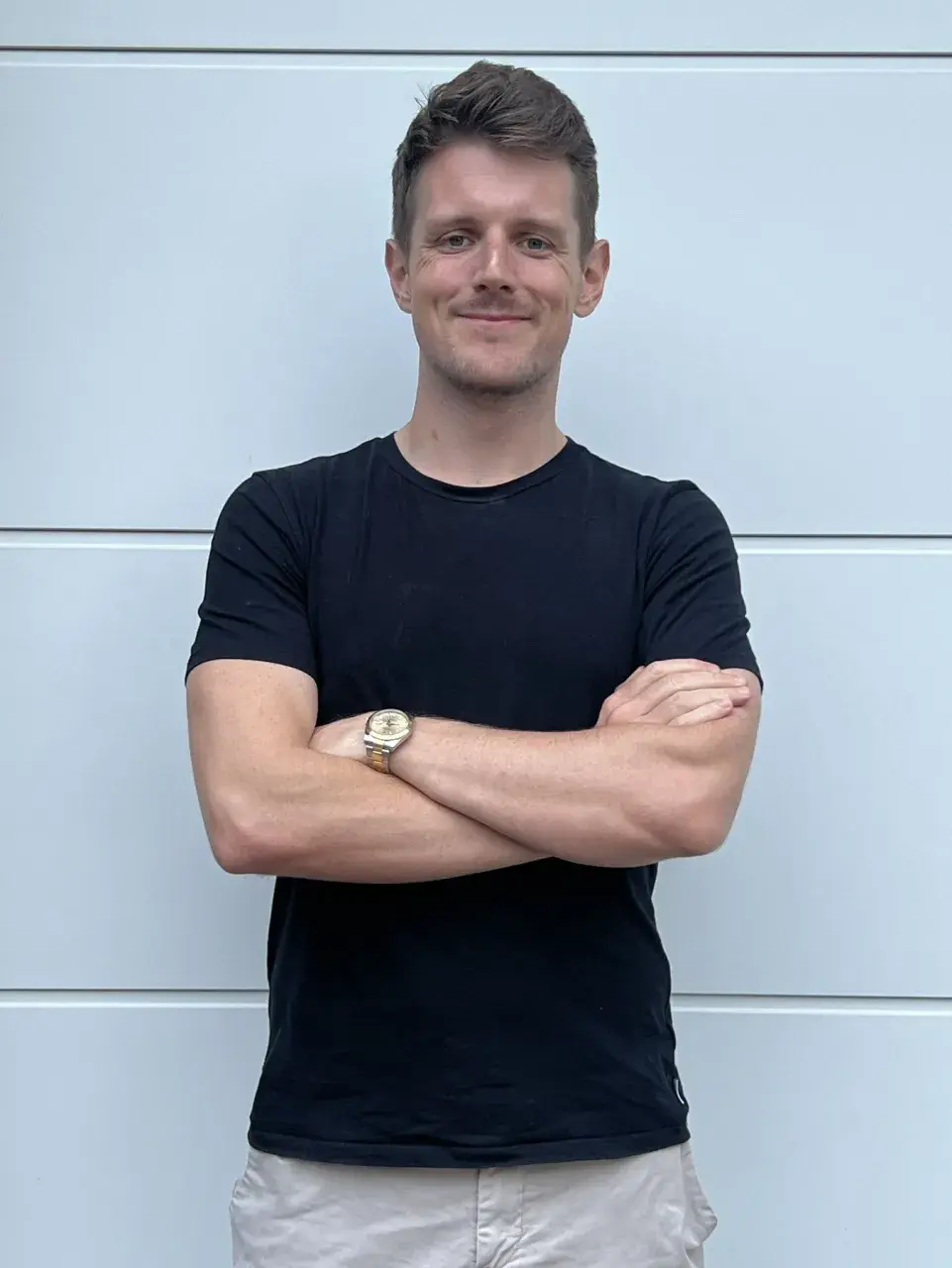 SuperJJ smiling with arms crossed